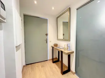 a bathroom with a sink and a mirror and a door at Appartement cosy au centre de Cannes in Cannes