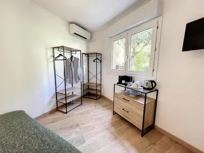 a bedroom with a bed and a dresser and a window at Appartement cosy au centre de Cannes in Cannes