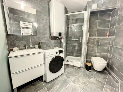 a bathroom with a washing machine and a toilet at Appartement cosy au centre de Cannes in Cannes