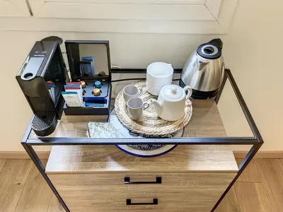 a glass table with two coffee cups and a phone at Appartement cosy au centre de Cannes in Cannes