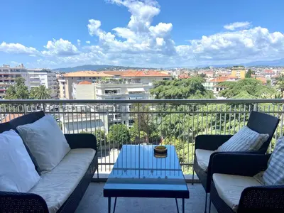 a balcony with two couches and a table with a view at Belle terrasse près du Martinez et des plages! in Cannes