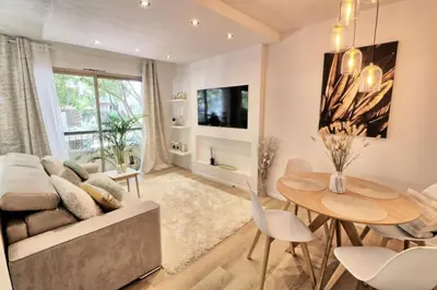 a living room with a couch and a table at Ref FLEUR - Palmes d'Or Properties in Cannes