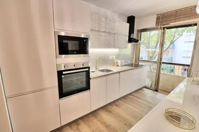 a white kitchen with a sink and a refrigerator at Ref FLEUR - Palmes d'Or Properties in Cannes