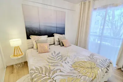 a bedroom with a bed with a large window at Ref FLEUR - Palmes d'Or Properties in Cannes