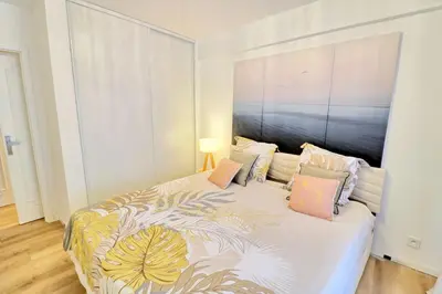 a bedroom with a large bed with colorful pillows at Ref FLEUR - Palmes d'Or Properties in Cannes
