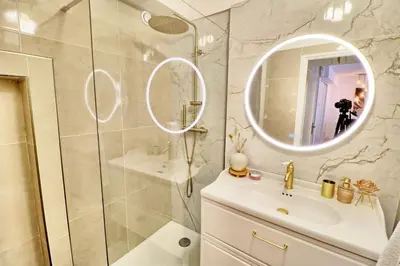 a bathroom with a shower and a sink and a mirror at Ref FLEUR - Palmes d'Or Properties in Cannes