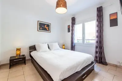 a bedroom with a large bed and a window at Cannes Branly :2BDR Apartment in Cannes