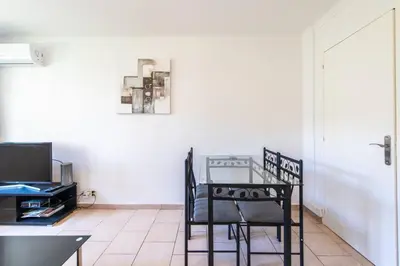 a dining room with a table and chairs and a television at Cannes Branly :2BDR Apartment in Cannes