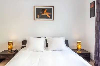 a bedroom with a white bed with two night stands at Cannes Branly :2BDR Apartment in Cannes