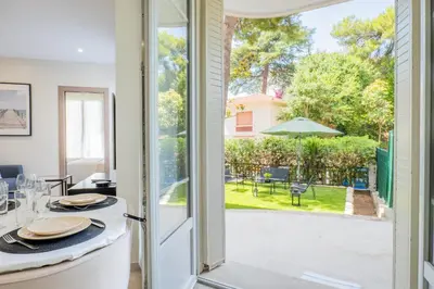 a kitchen and dining room with a door open to a patio at Garden-level apartment 10-min on foot to City Center in Cannes