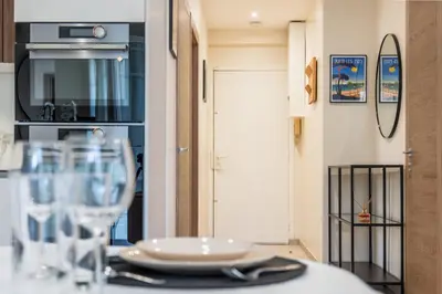 a table with glasses and a plate on it at Garden-level apartment 10-min on foot to City Center in Cannes