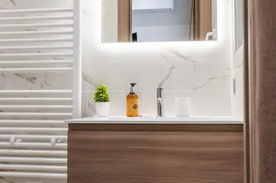 a bathroom with a sink and a mirror at Garden-level apartment 10-min on foot to City Center in Cannes