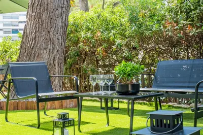 two chairs and a table in the grass at Garden-level apartment 10-min on foot to City Center in Cannes