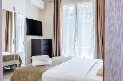 a hotel room with a bed and a large window at Garden-level apartment 10-min on foot to City Center in Cannes