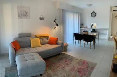 a living room with a couch and a dining room at Lovely cosy nest close to the centre of Cannes in Cannes
