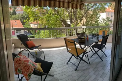 a patio with a table and chairs on a balcony at Lovely cosy nest close to the centre of Cannes in Cannes