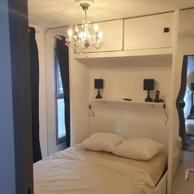 a bedroom with a bed with a chandelier above it at Appartement 172 in Cannes