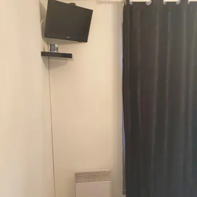 a flat screen tv on a wall next to a curtain at Appartement 172 in Cannes