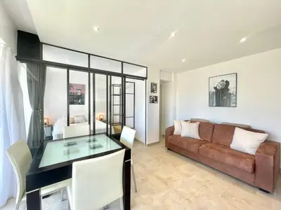 a living room with a couch and a glass table at Copacabana beach, by Welcome to Cannes in Cannes