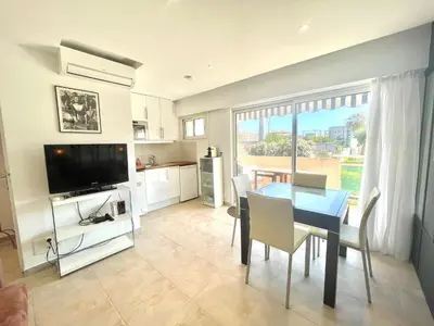 a kitchen and dining room with a table and a television at Copacabana beach, by Welcome to Cannes in Cannes