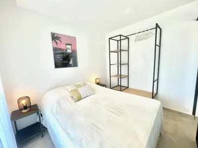 a white bedroom with a bed and a shelf at Copacabana beach, by Welcome to Cannes in Cannes