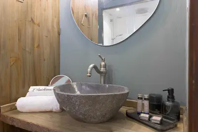 a bathroom with a stone sink and a mirror at 