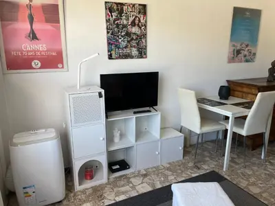 a living room with a tv and a desk with a computer at Studio in Cannes