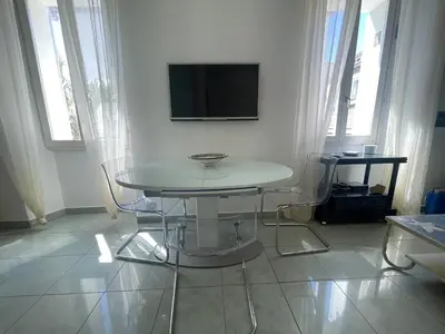 a white room with a table and a tv on a wall at 50 Mètres du Palais by Connexion in Cannes