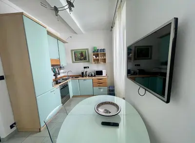 a kitchen with a table and a tv on a wall at 50 Mètres du Palais by Connexion in Cannes