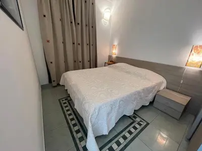 a small bedroom with a bed with a white blanket at 50 Mètres du Palais by Connexion in Cannes