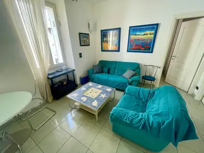 a living room with a blue couch and a table at 50 Mètres du Palais by Connexion in Cannes
