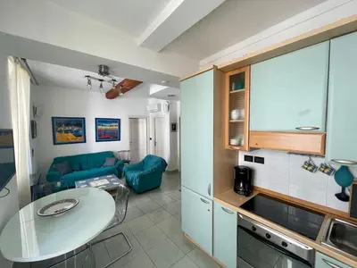 a kitchen and living room with a table and a couch at 50 Mètres du Palais by Connexion in Cannes