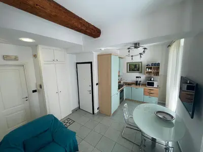 a kitchen with a glass table and a blue couch at 50 Mètres du Palais by Connexion in Cannes