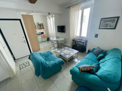 a living room with a blue couch and a table at 50 Mètres du Palais by Connexion in Cannes