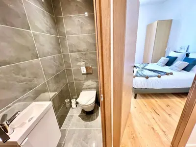 a bathroom with a shower and a toilet and a bed at L'Elégance Rue d'Antibes - Palais & Plages - 200 m Croisette - Parking privé - Clim - Wifi in Cannes