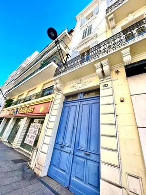 a building with a blue door on a street at L'Elégance Rue d'Antibes - Palais & Plages - 200 m Croisette - Parking privé - Clim - Wifi in Cannes