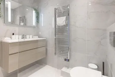 a white bathroom with a sink and a shower at L'Elégance Rue d'Antibes - Palais & Plages - 200 m Croisette - Parking privé - Clim - Wifi in Cannes
