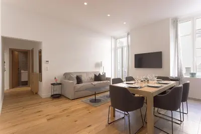 a living room with a table and a couch at L'Elégance Rue d'Antibes - Palais & Plages - 200 m Croisette - Parking privé - Clim - Wifi in Cannes
