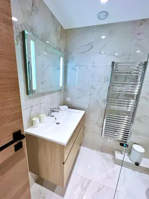 a bathroom with a sink and a mirror at L'Elégance Rue d'Antibes - Palais & Plages - 200 m Croisette - Parking privé - Clim - Wifi in Cannes