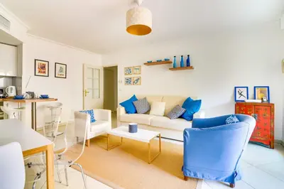 a living room with a white couch and blue chairs at Parc RL Perfect 1 bedroom apartment next to beaches and shops in Cannes