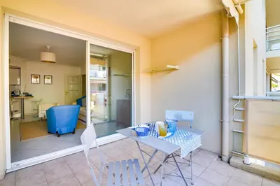 a patio with a table and chairs in a room at Parc RL Perfect 1 bedroom apartment next to beaches and shops in Cannes