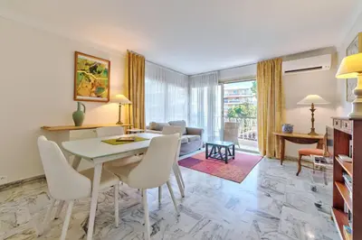 a living room with a table and chairs at Appartement le San Francisco bright and calm 3 bedroom flat in Cannes
