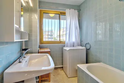 a bathroom with a sink and a tub and a window at Appartement le San Francisco bright and calm 3 bedroom flat in Cannes