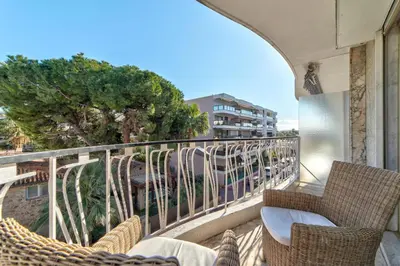 a balcony with wicker chairs and a view of a building at Appartement le San Francisco bright and calm 3 bedroom flat in Cannes