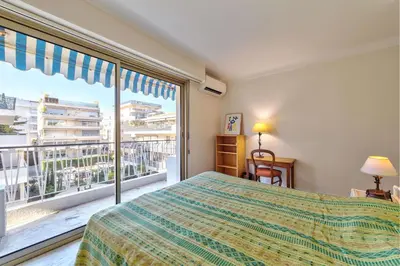 a bedroom with a bed and a large window at Appartement le San Francisco bright and calm 3 bedroom flat in Cannes