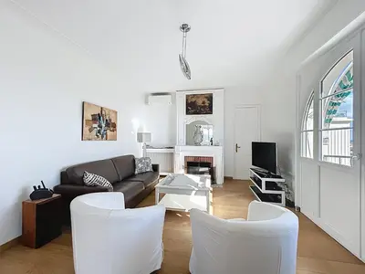 a living room with a couch and white chairs at Palais Alexandre III Magnificent 4 sea view 100m from the Croisette in Cannes