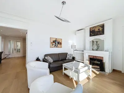 a living room with a couch and a fireplace at Palais Alexandre III Magnificent 4 sea view 100m from the Croisette in Cannes