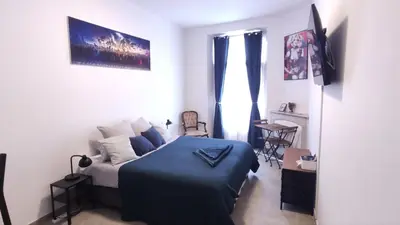 a bedroom with a bed with a blue blanket at Le QG - CANNES - Palais du Festival in Cannes