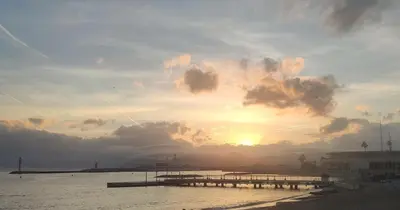 a sunset over a body of water with a pier at Le QG - CANNES - Palais du Festival in Cannes