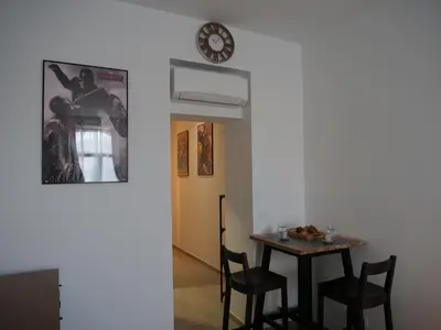 a dining room with a table and chairs and a clock at Le QG - CANNES - Palais du Festival in Cannes